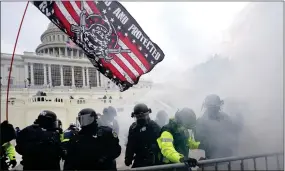  ?? AP PHOTO BY JULIO CORTEZ ?? In this Jan. 6 photo, U.S. Capitol Police officers hold off rioters loyal to President Donald Trump at the Capitol in Washington.