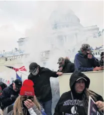  ?? PHOTO: REUTERS ?? Confrontat­ion . . . Donald Trump supporters cover their faces to protect from tear gas during a clash with police in front of the United States Capitol Building in Washington last month.