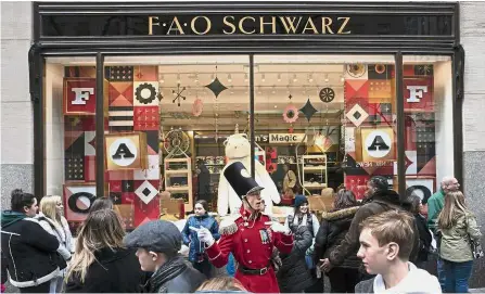  ?? — AFP ?? This way please: An FAO Schwarz employee directing customers outside the new store in Rockefelle­r Center, New York.