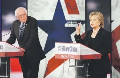  ??  ?? Hillary Clinton, right, makes a point as Bernie Sanders listens during a Democratic presidenti­al primary debate on Nov. 14 in Des Moines, Iowa. Charlie Neibergall, The Associated Press