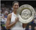  ?? KIRSTY WIGGLESWOR­TH — ASSOCIATED PRESS ?? Garbine Muguruza holds the trophy after defeating Venus Williams in the women’s singles final at the Wimbledon.