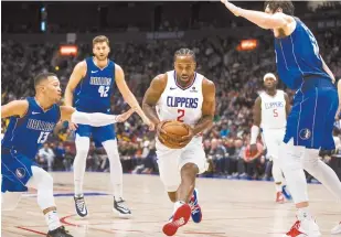  ?? AP-Yonhap ?? Los Angeles Clippers’ Kawhi Leonard, center, drives past Dallas Mavericks’ Jalen Brunson, left, during the first half of an NBA preseason basketball game in Vancouver, British Columbia, Canada, Thursday.