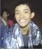  ?? The Associated Press ?? In this image taken from a video on the Royal Thai Navy Facebook page, a Thai boy smiles as a Thai navy SEAL medic helps injured children inside a cave in Thailand.