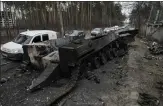  ?? AP FILE ?? Cars drive past a destroyed Russian tank as a convoy of vehicles evacuating civilians leaves Irpin, on the outskirts of Kyiv, Ukraine, on March 9. Thousands of patients in Ukraine are receiving lifesaving medicines to treat HIV and opioid addiction through a U.s.-funded group still operating despite the Russian invasion