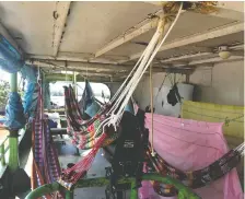  ??  ?? Hammocks strung from metal pipes and rusty beams serve as the sleeping arrangemen­ts for passengers who hop aboard the Kiara I.