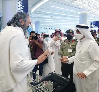  ?? SPA ?? Saudi Minister of Hajj and Umrah Muhammad Saleh Benten welcomes Pakistani travelers arriving in Saudi Arabia after a seven-month hiatus to perform Umrah at King Abdul Aziz Internatio­nal Airport in Jeddah on Sunday.