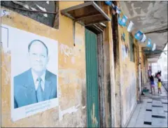  ?? HONG MENEA ?? CPP banners and a poster featuring National Assembly President Heng Samrin adorn an alleyway at a Borei Keila building.