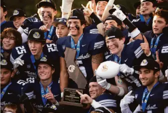  ?? D. Ross Cameron / Special to The Chronicle ?? Marin Catholic players pose for a group photo with the state championsh­ip trophy following a CIF Division 4-AA victory over Central Valley Christian-Visalia, 34-14.