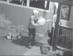  ??  ?? A video image released by the RCMP shows a man pouring liquid on a West Vancouver home in January. Seconds later, the man set the liquid alight.