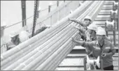  ?? XINHUA ?? Technician­s from China Communicat­ions Constructi­on Co Ltd check cables of a bridge in Chongqing.