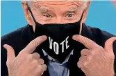  ??  ?? US President-elect Joe Biden points to his mask with the word “Vote” printed on it (AFP)