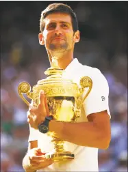  ?? Clive Brunskill / Getty Images ?? Novak Djokovic celebrates with the trophy after winning the men's singles final at Wimbledon on Sunday.