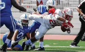  ?? Tim Warner / Contributo­r ?? Katy running back Jalen Davis dives for a one of his three touchdowns Saturday in the Tigers’ victory over Clear Springs at Challenger Columbia Stadium.