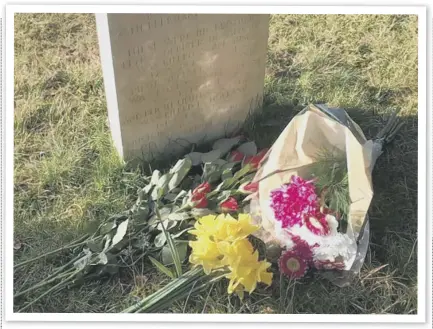  ??  ?? Flowers laid by members of Flashback Midhurst on the anniversar­y of Flight Lieutenant John Cuthbert Garland’s death