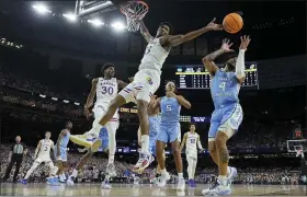  ?? DAVID J. PHILLIP — THE ASSOCIATED PRESS ?? Kansas forward David McCormack vies for a loose ball with North Carolina guard R.J. Davis during the first half of a college basketball game in the finals of the Men’s Final Four NCAA tournament, Monday, in New Orleans.