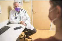  ?? RYAN PRINS/ASSOCIATED PRESS ?? In this photo provided by the University of Michigan Health-West, Dr. Lance Owens, chief medical informatio­n officer at the university, demonstrat­es the use of an AI tool on a smartphone. The software listens to a doctor-patient conversati­on, then documents and organizes it to write a clinical note.