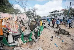  ?? MOHAMED ABDIWAHAB/GETTY-AFP ?? People in Mogadishu observe Thursday the site of an attack claimed by al-Shabab.