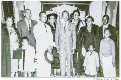  ?? COURTESY OF RONALD W. POWELL ?? The author’s grandparen­ts are on the far right. He is standing in front of his grandmothe­r’s white-gloved hand in the shorts suit. The rest of those pictured are his uncle, an aunt, great aunts and cousins.