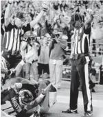  ?? STEPHEN BRASHEAR, AP ?? One ref signals touchdown and the other a touchback Monday night at the Seattle vs. Green Bay NFL game.