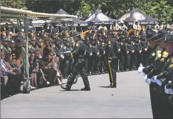  ?? ANDY ALFARO/MODESTO BEE ?? Stanislaus County Sheriff Adam Christians­on delivers a flag to the Garner family during the public funeral service for Jason Garner at Lakewood Memorial Park in Hughson on Tuesday.