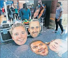  ?? [BARBARA J. PERENIC/DISPATCH] ?? Fans feel a kinship with the team — even holding up giant cardboard heads of their favorite players — by attending games and participat­ing in the extra activities that a National Hockey League team holds. This was at a sign-up for the 5th Line 5k at Nationwide Arena in February.