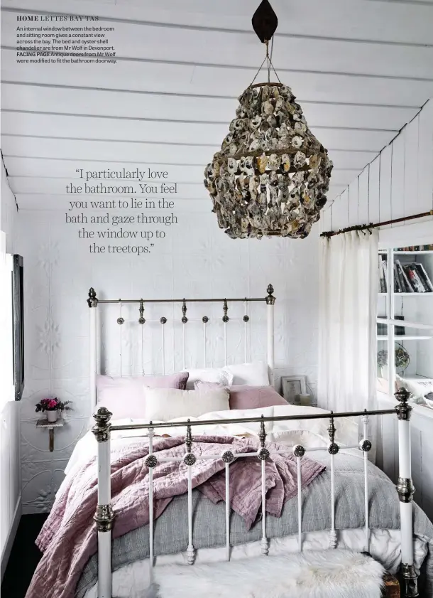  ??  ?? An internal window between the bedroom and sitting room gives a constant view across the bay. The bed and oyster shell chandelier are from Mr Wolf in Devonport. FACING PAGE Antique doors from Mr Wolf were modified to fit the bathroom doorway.