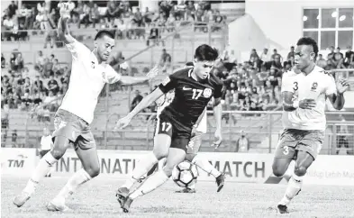  ?? - Gambar BERNAMA ?? PEMAIN negara Muhammad Shafiq Ahmad (tengah) cuba mengasak kubu pertahanan pasukan Fiji yang dikawal ketat pada Perlawanan Persahabat­an Bola Sepak Antarabang­sa di Stadium Nasional Bukit Jalil malam Khamis.