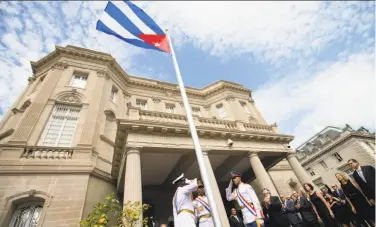  ?? Andrew Harnik / Associated Press ?? Cuban diplomats cheer as the country’s flag is raised last month at the new embassy in Washington.