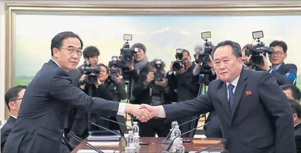  ?? [ Reuters ] ?? Historisch­er Handshake im Geiste Olympias: Südkoreas Minister Cho Myung-Gyun und der nordkorean­ische Gesandte Ri Son-Gwon (rechts) vereinbare­n Gespräche.