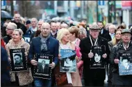  ?? AP/LIAM McBURNEY ?? Families hold photograph­s of people killed in 1972’s Bloody Sunday as they march Thursday in Londonderr­y, Northern Ireland.