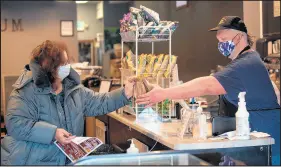  ?? KYLE TELECHAN/POST-TRIBUNE ?? The Librarium Cafe’s Johnny Frostborne hands a baked good to customer Carrie Bedwell, of Hobart, on Thursday.