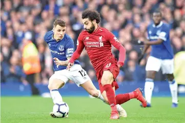  ??  ?? Everton’s French defender Lucas Digne (L) vies with Liverpool’s Egyptian midfielder Mohamed Salah during the English Premier League football match between Everton and Liverpool at Goodison Park in Liverpool, north west England. - AFP photo