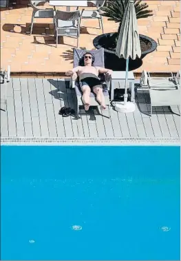  ?? JAIME REINA / AFP ?? Un turista tomando el sol en un hotel de Mallorca, ayer