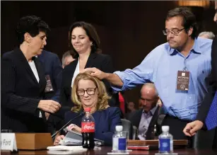  ?? AP PHOTO SAUL LOEBP ?? Christine Blasey Ford is patted on the head by Keith Kogner as she finishes testifying.