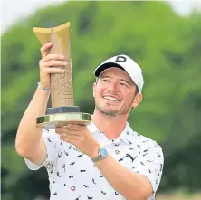  ?? ?? Ewen Ferguson is all smiles as he lifts the trophy.