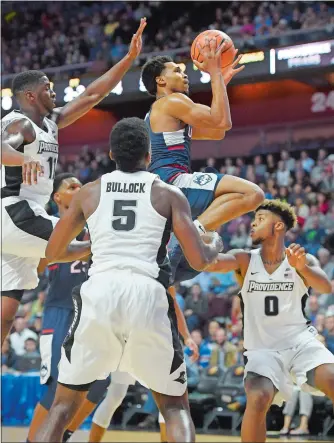  ?? JOHN WOIKE/HARTFORD COURANT/AP PHOTO ?? Jalen Adams of UConn drives between, from left, Alpha Diallo, Rodney Bullock and Nate Watson of Providence College during the first half of an exhibition game at Mohegan Sun Arena on Wednesday night. Adams scored 22 points but Providence won 90-76.