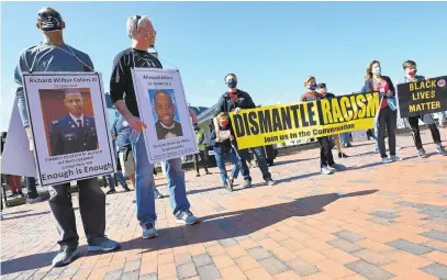  ?? BRIAN KRISTA/BALTIMORE SUN MEDIA ?? Supporters of the 1,000 Men March hold signs upon gathering for speeches Saturday at Susan Campbell Park in Annapolis. The event was organized by the United Black Clergy of Anne Arundel County and several other community groups.