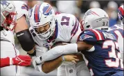  ?? TOWNSON/ASSOCIATED PRESS WINSLOW ?? Bills quarterbac­k Josh Allen hangs onto the ball while being hit by Patriots free safety Devin Mccourty during this past Sunday’s 33-21 win in New England.