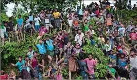  ?? BERNAT ARMANGUE/AP PHOTO ?? Rohingya Muslims stand to receive food being distribute­d Wednesday near Balukhali refugee camp in Cox’s Bazar, Bangladesh.