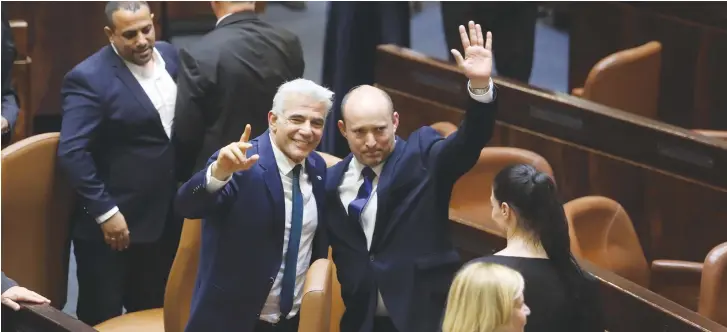  ?? (Marc Israel Sellem/The Jerusalem Post) ?? PRIME MINISTER Naftali Bennett and Foreign Minister Yair Lapid acknowledg­e well-wishers after the swearing in of the government yesterday at the Knesset.