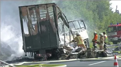  ?? NEWS 5 VIA REUTERS ?? Firefighte­rs are seen at the site where a coach burst into flames after colliding with a truck on a motorway near Muenchberg, Germany, on Monday.