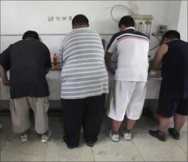  ?? THE ASSOCIATED PRESS ?? In this Thursday, July 24, 2008 file photo, obese patients wash their plates after lunch at the Aimin Fat Reduction Hospital in Tianjin, China. The hospital uses a combinatio­n of diet, exercise and traditiona­l Chinese acupunctur­e to treat rising...