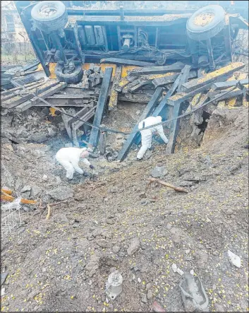  ?? The Associated Press ?? In this image made available by Polish Police, experts look through the site where a Russian-made missile hit Wednesday , killing two in Przewodowo, eastern Poland.