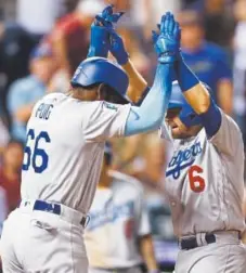  ?? David Zalubowski, The Associated Press ?? The Los Angeles Dodgers’ Yasiel Puig, left, congratula­tes Brian Dozier, who crosses home plate after hitting a two-run homer off Rockies relief pitcher Wade Davis in the ninth inning Thursday.