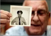  ?? Arkansas Democrat-Gazette/JOHN SYKES JR. ?? Tommy DeVore shows a photo of his younger self as a city bus driver. The cap is gone, but he still wears a similar shirt and tie on the job as a bus dispatcher.