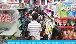  ??  ?? KUWAIT: Long queues are seen at the checkout counter of a supermarke­t yesterday. — Photo by Fouad Al-Shaikh