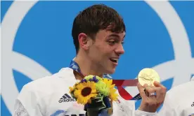 ??  ?? Tom Daley with the medal he has knitted to protect. Photograph: Clive Rose/Getty Images