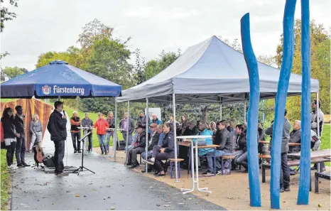  ?? FOTO: WAIBEL ?? Die weithin sichtbaren blau gestrichen­en Robinienst­ämme zeigen auch in Mühlheim die Donauperle an, die von Bürgermeis­ter Jörg Kaltenbach (links) der Öffentlich­keit übergeben wurde.