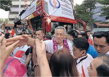  ??  ?? Prime Minister Lee Hsien Loong shakes hands with voters in his constituen­cy on Saturday to thank them for their support in the election.