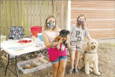  ?? (NWA Democrat-Gazette/Lynn Kutter) ?? Hadleigh Mays, 9, and Kinley Ault, 10, both of Prairie Grove, have set up their own booth at Prairie Grove Farmers Market called K&H Crafts and Crap. They are selling homemade items, including paintings, birdfeeder­s and other crafts. The girls also are making homemade doggie treats and all proceeds from the treats go to Friends of Prairie Grove Pound. The treats, called Doggie Ravioli, are made of peanut butter, pumpkin, egg and flour. They had donated $150 to the Friends’ organizati­on at this point.